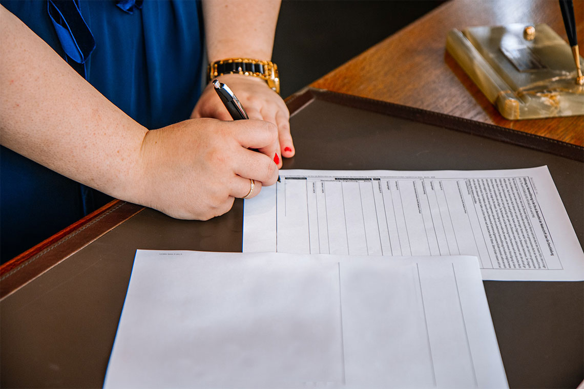 A Woman Puts Her Signature On A Form