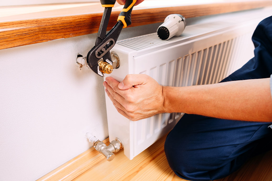 A Handyman Is Doing An Urgent Repair Of Heating For Tenants